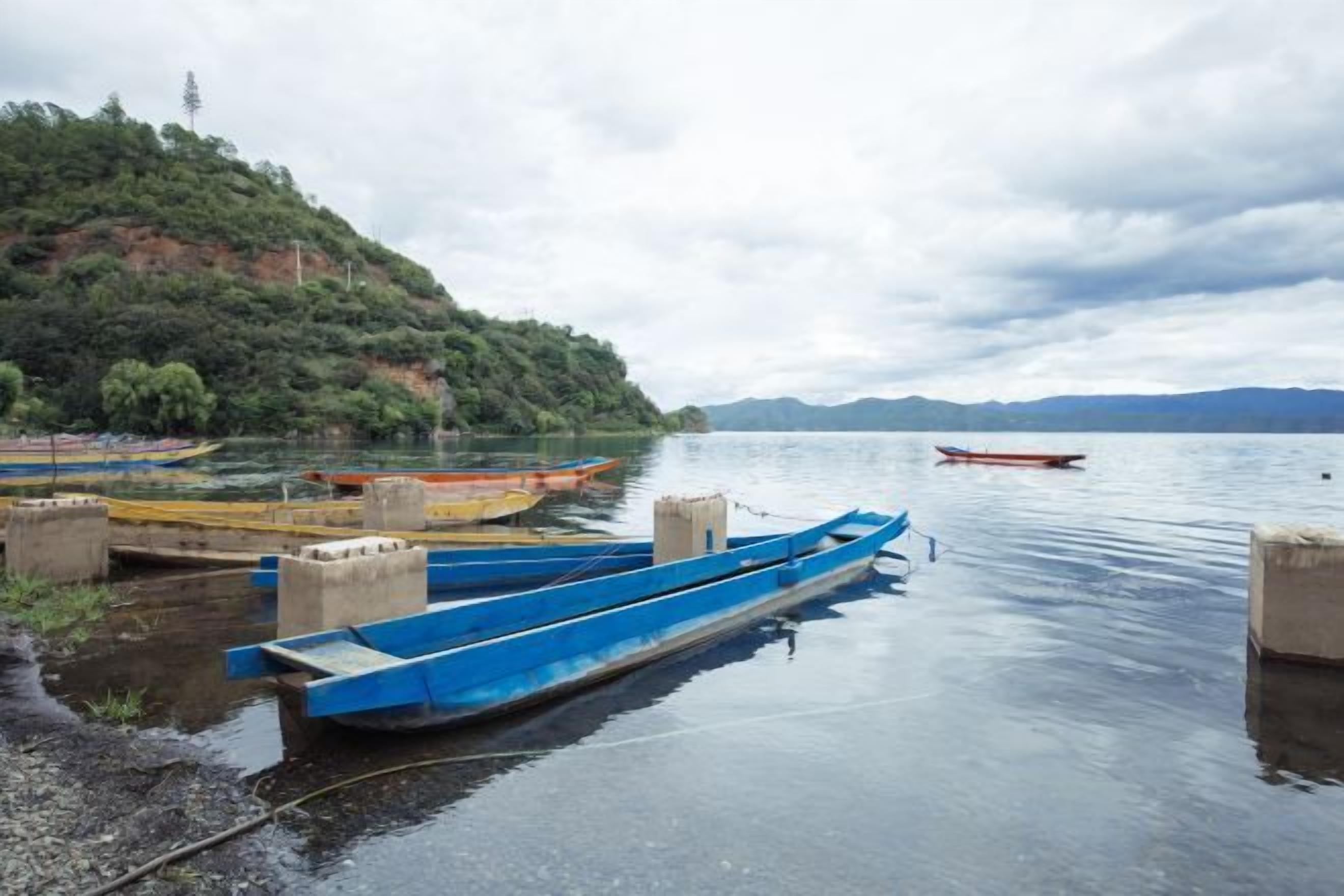 Un lago tranquilo con barcos amarrados en la orilla.