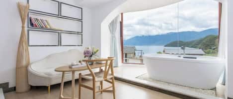 Un baño moderno con una bañera independiente, un sofá blanco y una mesa de madera.