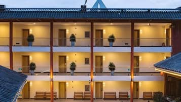Een meerlaags gebouw met balkons, plantenbakken en een overdekt terras.