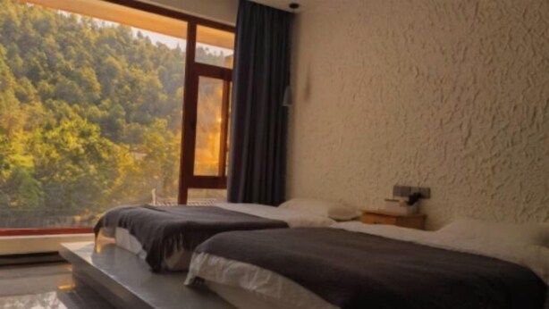A bedroom with two beds, a large window, and a view of a forest. - Lugu Lake Jimei Du Nuo Wu Yun Inn (Ninglang)