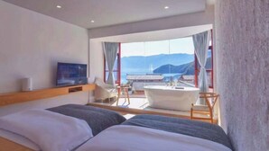 A hotel room with two beds, a bathtub, a television, and a large window with a mountain view. - Lugu Lake Jimei Du Nuo Wu Yun Inn (Ninglang)