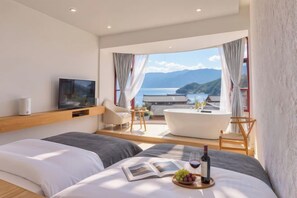 Une chambre d’hôtel moderne avec un grand lit, une baignoire et une vue sur la mer.