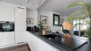 A modern kitchen with a central island, built-in appliances, and a large window. - Apartment "La Perla de Marakech 5" with Sea View, Shared Pool & Wi-Fi (Casares)