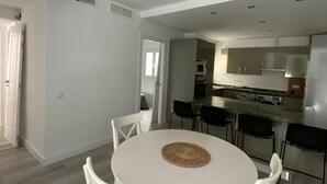 A modern kitchen with white cabinets, a microwave, and a refrigerator.