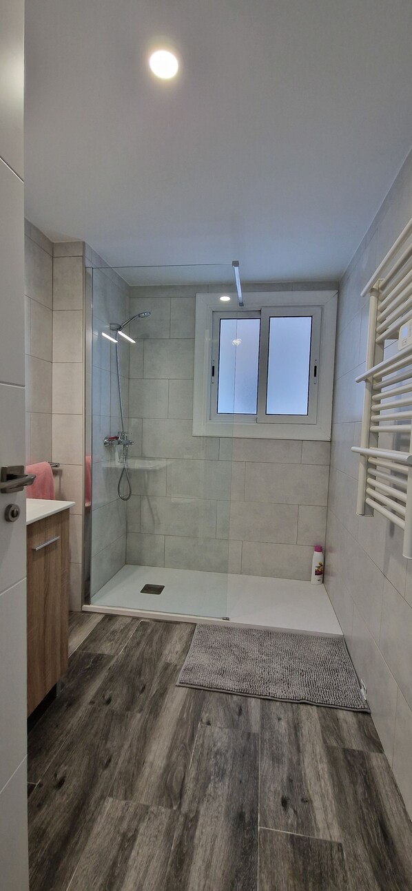 Regadera, secadora de cabello, toallas, papel de baño