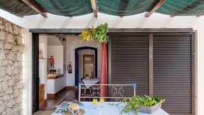 Une pièce avec une table mise pour le petit-déjeuner, une plante suspendue et une vue sur l’extérieur.