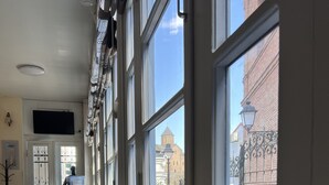A train carriage with large windows, a laptop on a table, and a view of a building outside. - TbilHome hostel (Tbilisi)