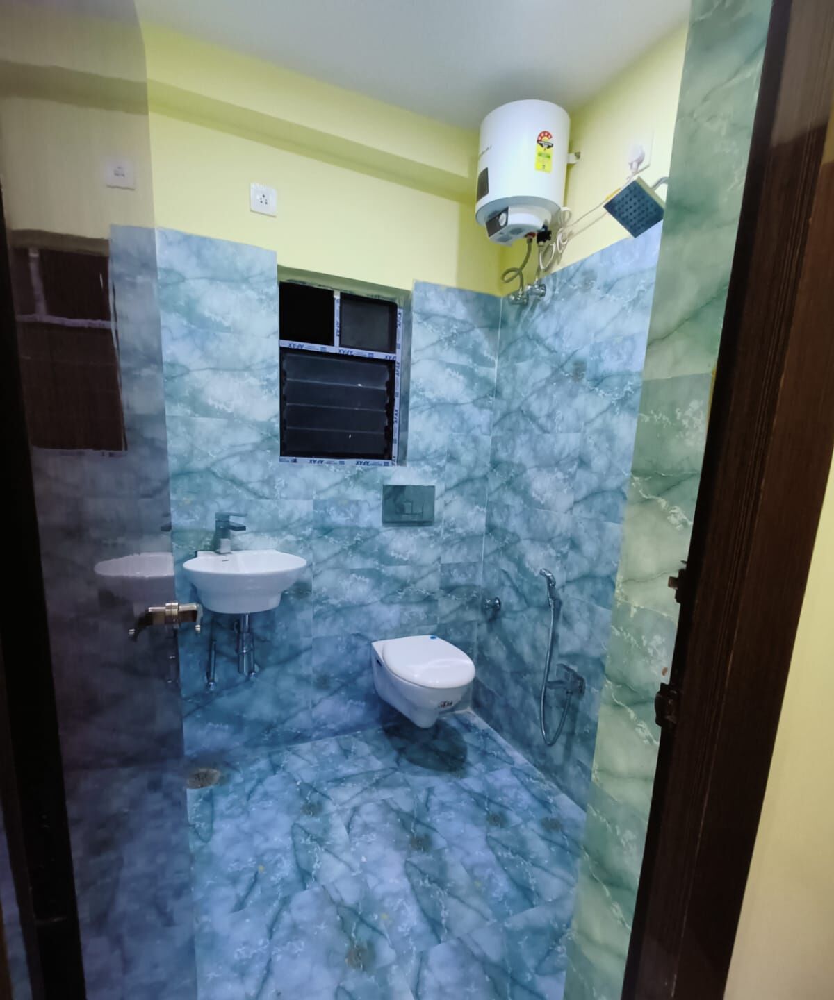 Een badkamer met twee wasbakken, een toilet en een douche.