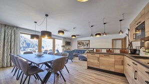 Cozinha moderna com armários de madeira, ilha central e iluminação pendente.