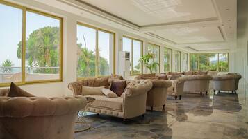 A spacious living room with large windows, a fireplace, and a view of the outdoors.