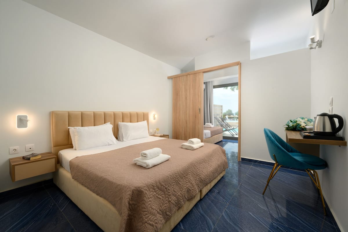 Een moderne hotelkamer met een groot bed, een bureau en een stoel.