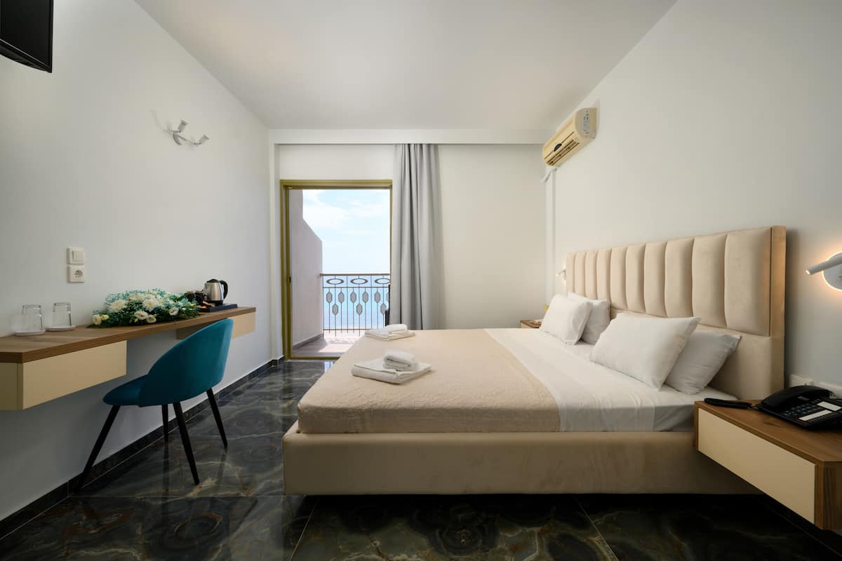 Hotelkamer met een bed, een bureau, een stoel en uitzicht.