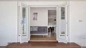 Un intérieur moderne avec un canapé gris, un escalier en bois et un tapis à motifs.