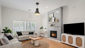 Un salon moderne avec un canapé, une table basse et une cheminée.