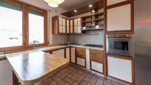 A kitchen with wooden cabinets, a gas stove, a sink, and a built-in oven.