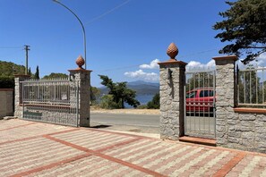 A gated entrance with stone pillars and metal gates, leading to a paved driveway. - Villetta Grazia - 1 (Capoliveri)