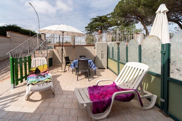 A patio area with a table, chairs, and umbrellas. - Villetta Grazia - 1 (Capoliveri)