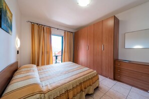 Una camera da letto con un letto, un armadio in legno e una TV.