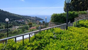 A balcony with a railing, a street lamp, and a view of the sea and hills. - Vlletta Grazia 2 apartment (Capoliveri)
