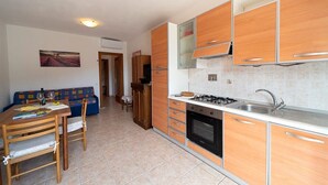A compact kitchen with wooden cabinets, a gas stove, and a sink.