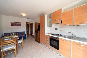 A compact kitchen with wooden cabinets, a gas stove, and a sink.