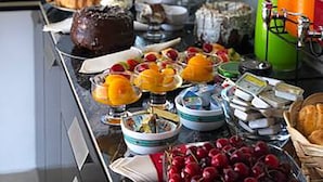 Ein reichhaltiges Buffet mit verschiedenen Speisen und Getränken, darunter Backwaren, Früchte und eine Kaffeestation.