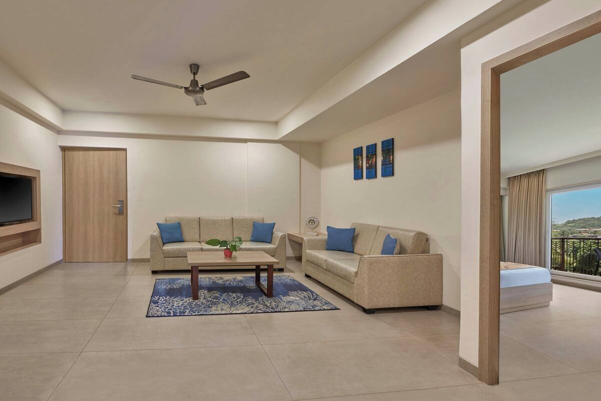 A modern living room with a sofa set, a coffee table, and a ceiling fan.