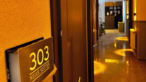 En hotellkorridor med en skylt som visar "Rum 303, nära sviterna".