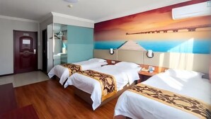 Habitación de hotel con dos camas, suelo de madera, un mural grande de una puesta de sol sobre el agua y una puerta con espejo.