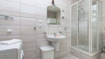 Bathtub, hair dryer, towels, shampoo