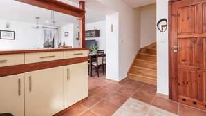 Een keuken met een houten aanrecht, kasten en een eethoek met stoelen en een tafel.