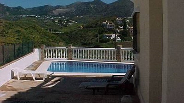 Ein Poolbereich mit Blick auf Berge und Häuser.