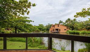 Une maison avec vue sur un étang et la végétation environnante.