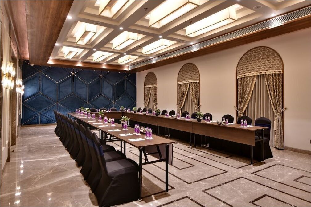 A conference room with a long table, chairs, and a patterned wall.