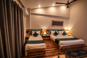 A hotel room with two beds, wooden headboards, a geometric-patterned wall art, and a ceiling fan. - Hotel Square One By D'Polo Dharamshala  ID 92552899 (Dharamshala)