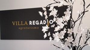 A reception area with a black sign reading "VILLA REGADO agroturismo" and a cactus-shaped sign with the text "Home Is Where your heart is." - Villa Regadio (Covilhã)