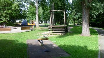 A park with a swing set, benches, and a playground.