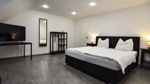 A modern bedroom with a large bed, a TV, a wardrobe, and a mirror. - Hotel Schlemmerscheune (Weilerbach)