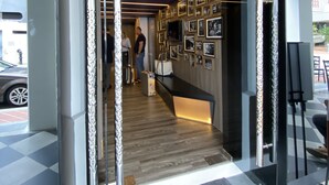An entrance with a wooden floor, a reception desk, and a wall decorated with framed pictures. - ST Signature Tanjong Pagar, SHORT OVERNIGHT, 12 hours: 8PM-8AM (Singapore)
