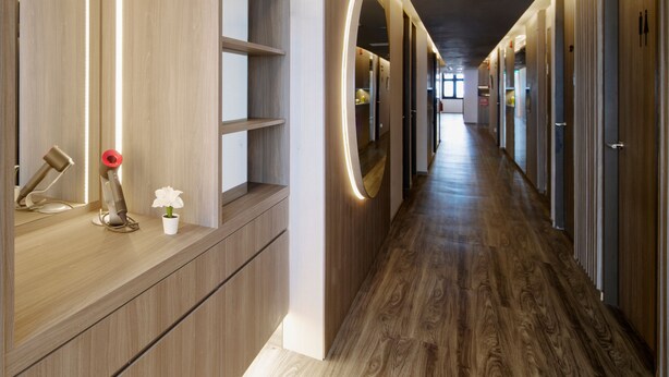 A modern hotel corridor with wooden flooring, built-in shelving, and circular wall sconces. - ST Signature Tanjong Pagar, SHORT OVERNIGHT, 12 hours: 8PM-8AM (Singapore)