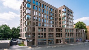 A multi-story building with a brick facade, large windows, and a flat roof. - Apartment 107 - A premium stay that sleeps 4 guests  in 2 bedrooms (York)