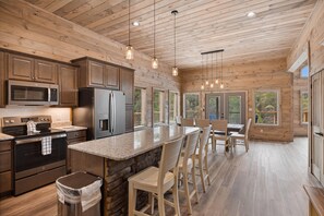 Una cocina moderna con encimeras de granito, electrodomésticos de acero inoxidable y armarios de madera.