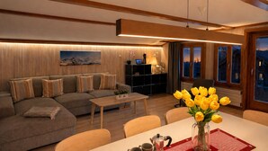 En moderne stue med sofa, sofabord og spiseplads.