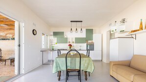 A modern kitchen with a dining table, chairs, and a sofa. - 3233 Villa Lucechiara by Barbarhouse (Avetrana)