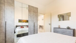A bedroom with a large bed, a wardrobe with a mirror, and a dresser. - 3230 Villino Dalila by Barbarhouse (Maruggio)