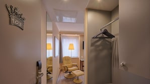 Una habitación de hotel con ducha, una silla, un escritorio y una lámpara.