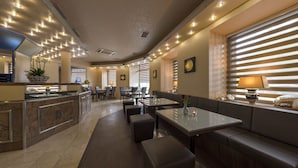 Un restaurante moderno con una barra alargada, mesas y un área de bar.