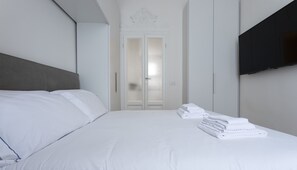 Enjoy a restful stay in this stylish room with a neatly made bed, flat-screen TV, and clean, uncluttered space.