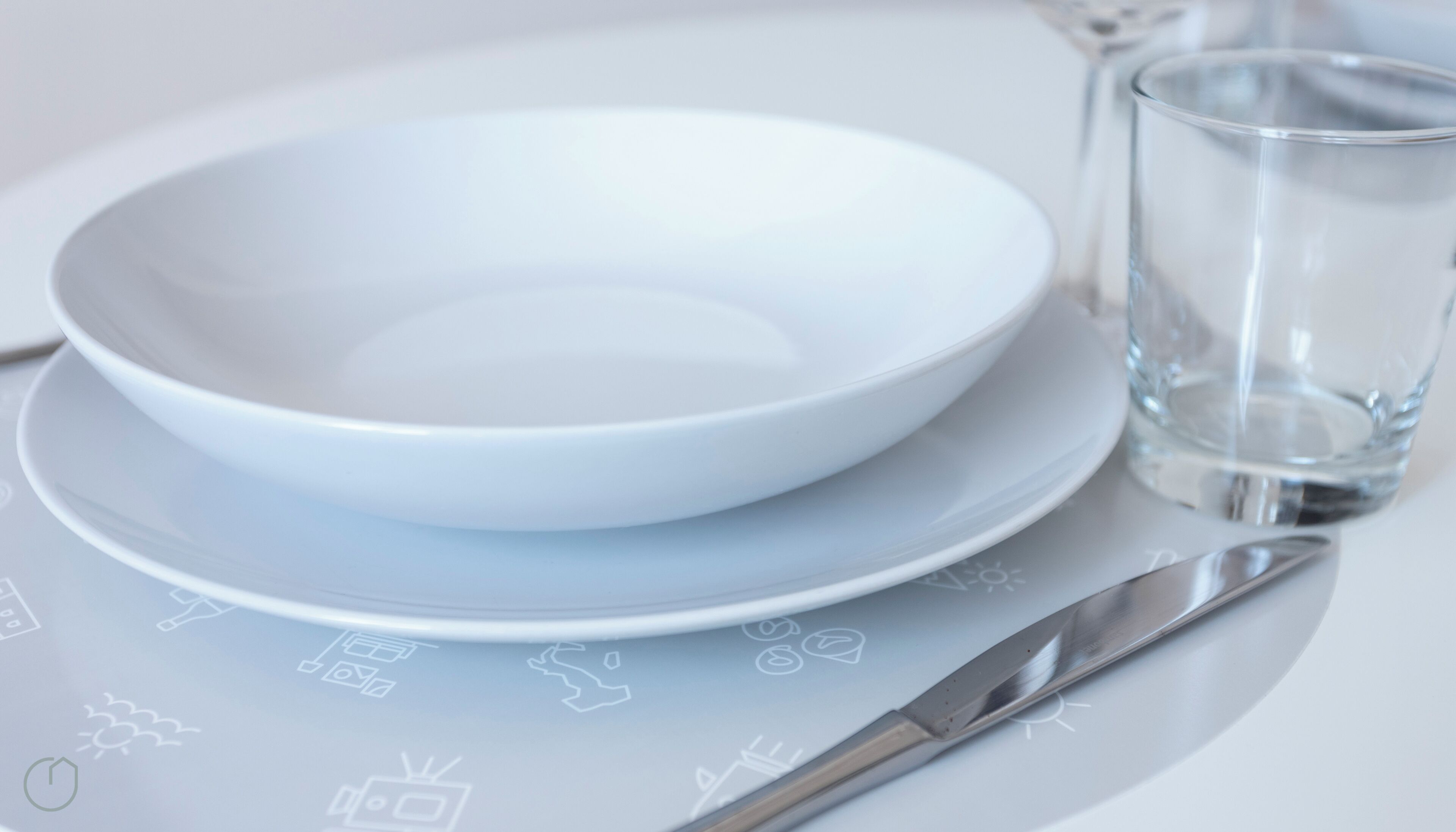 A white table with a bowl, a glass, and a knife.
