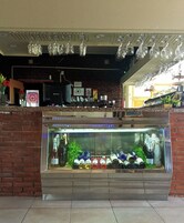 Zona de bar con una exhibición de botellas de vino y una lámpara colgante.